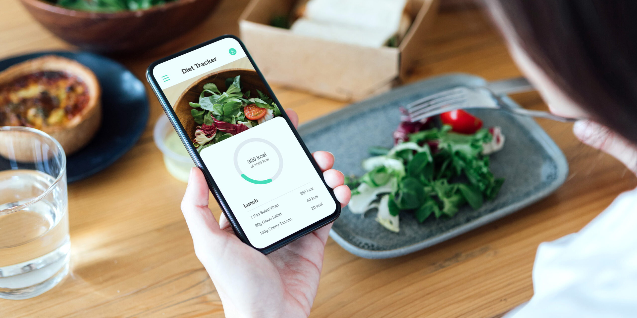 Young Woman Counting Calories With Smartphone While Eating