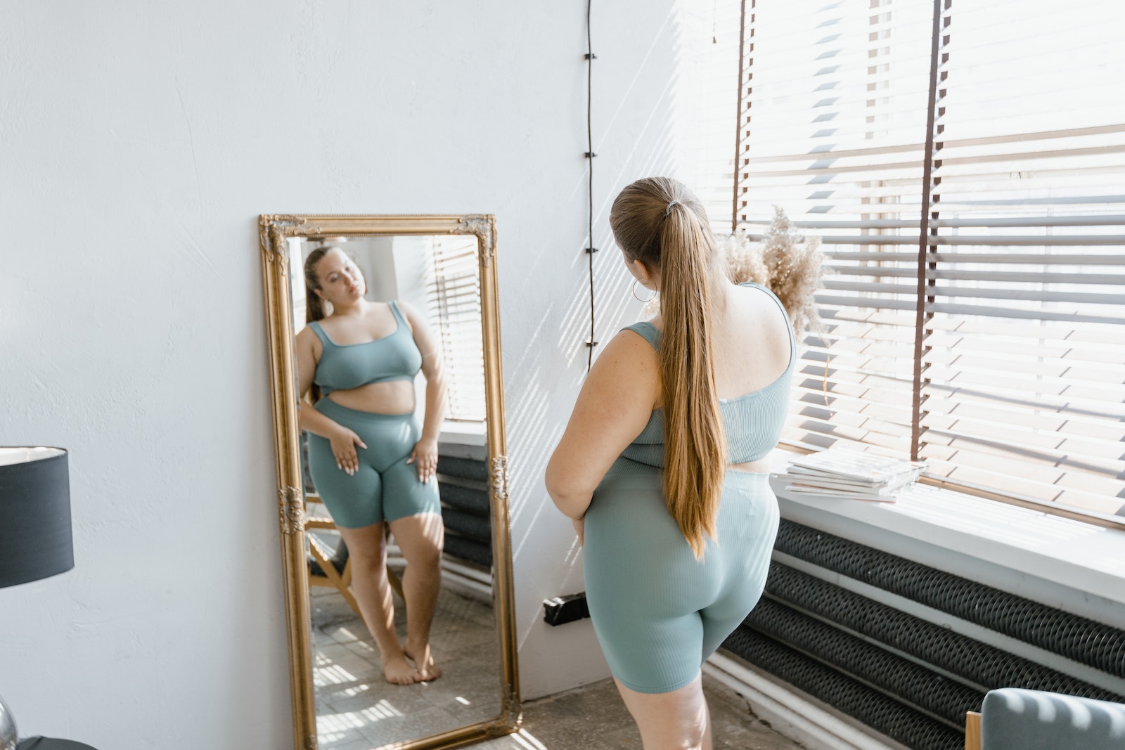 How Social Media Impacts Body Image woman looking at mirror