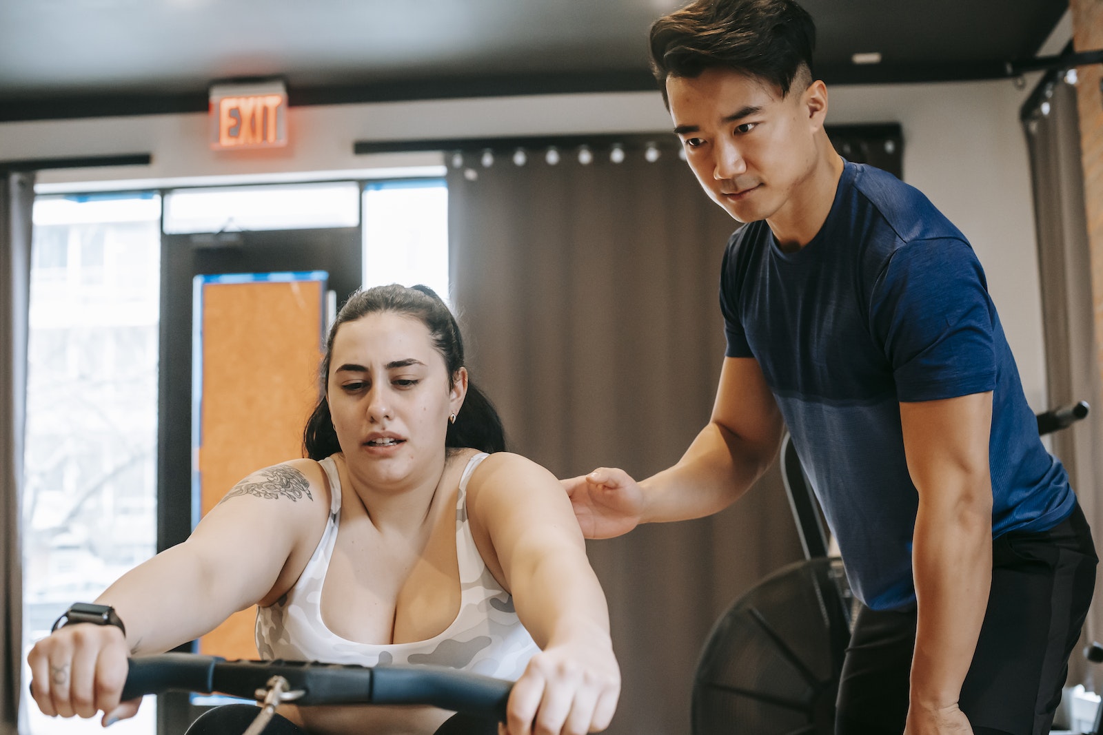 trainer supporting woman working out