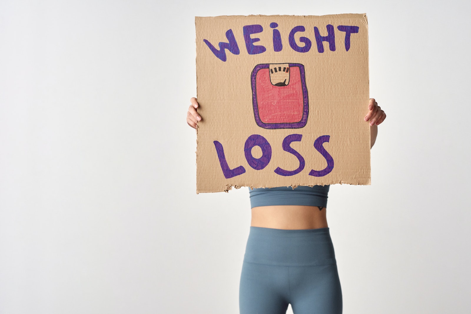 woman holding a sign of weight loss