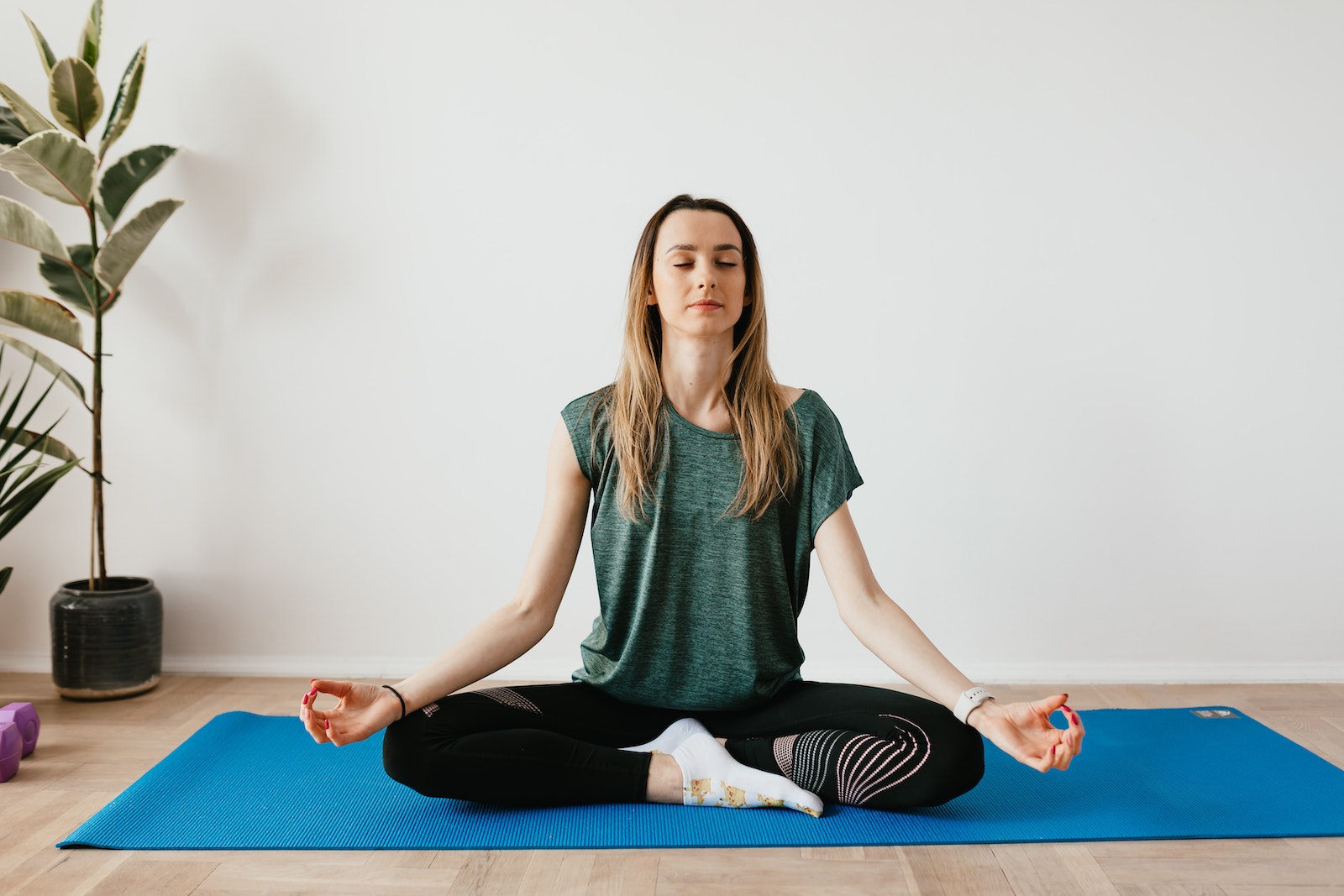 woman sitting practicing yoga at home