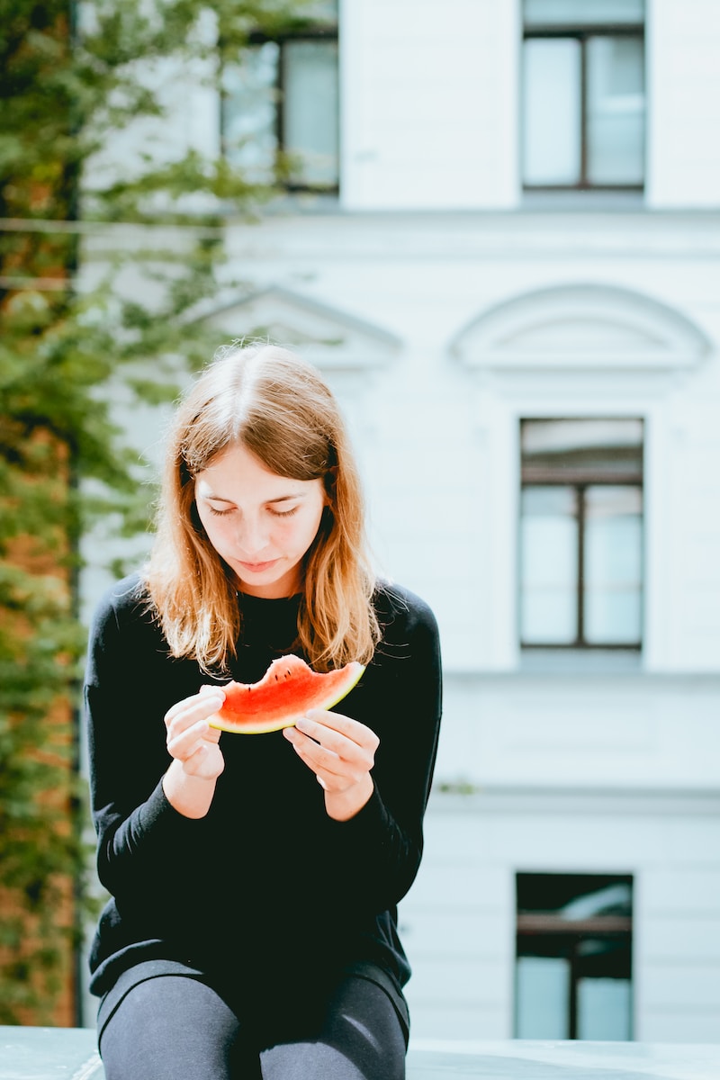woman holding slice of watermelon