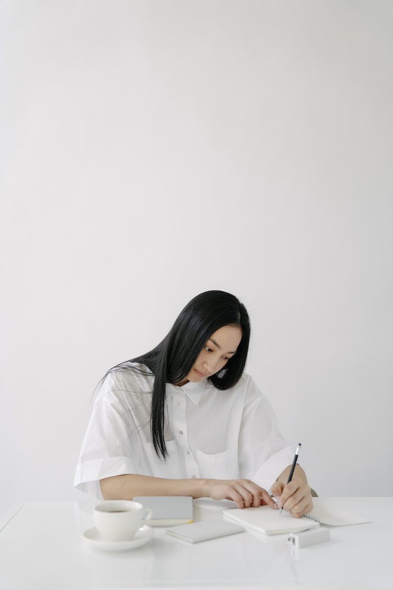 young female taking notes in journal
