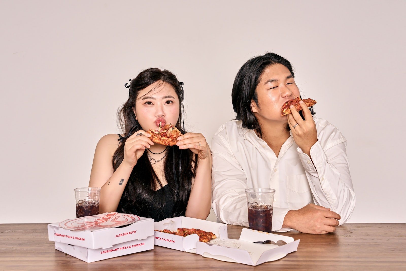 man and woman eating pizza