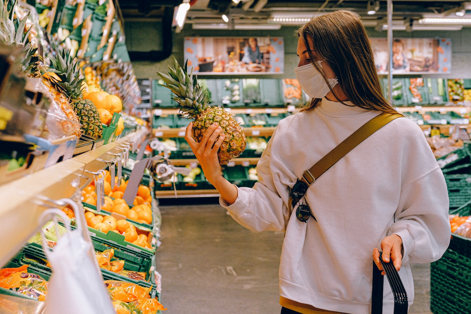 Woman in Supermarket holding a pineapple
