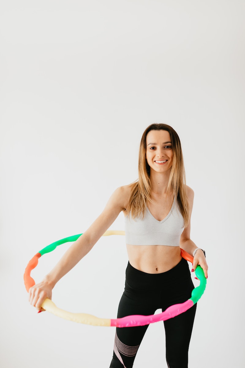 sportswoman exercising with hula hoop