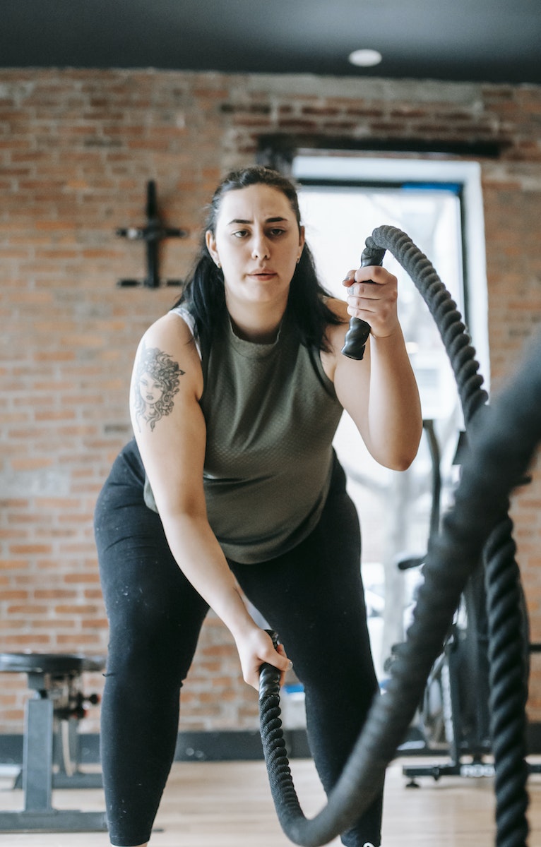 woman exercising with heavy battle ropes