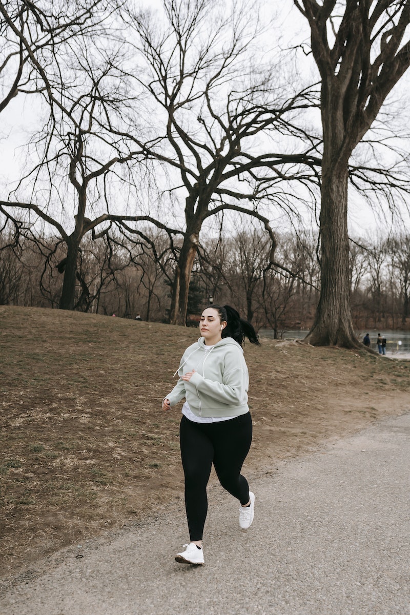motivated female running in autumn park